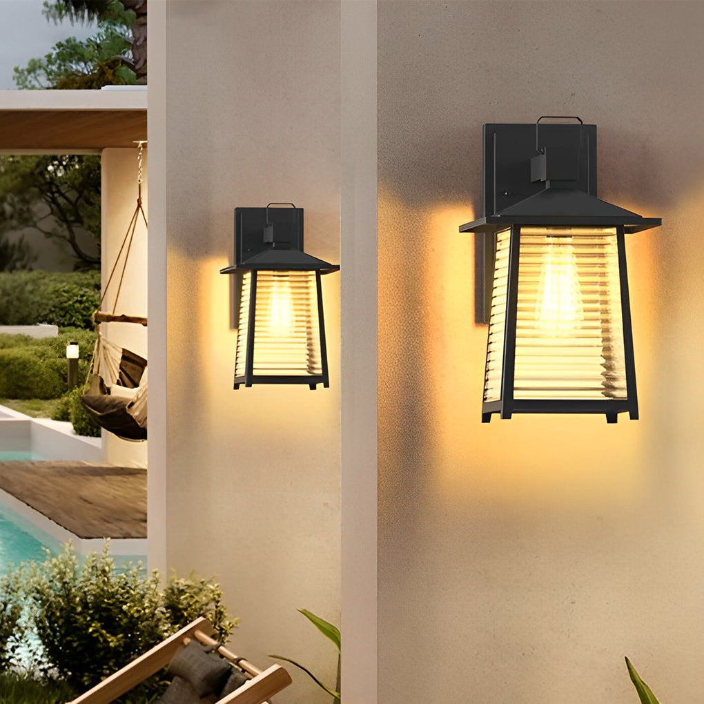 Lantern outdoor wall light with clean lines, illuminating a poolside seating area at dusk.
