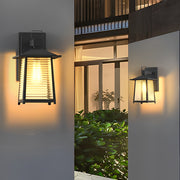 Lantern outdoor wall light with horizontal slats, providing warm light for a welcoming porch atmosphere.