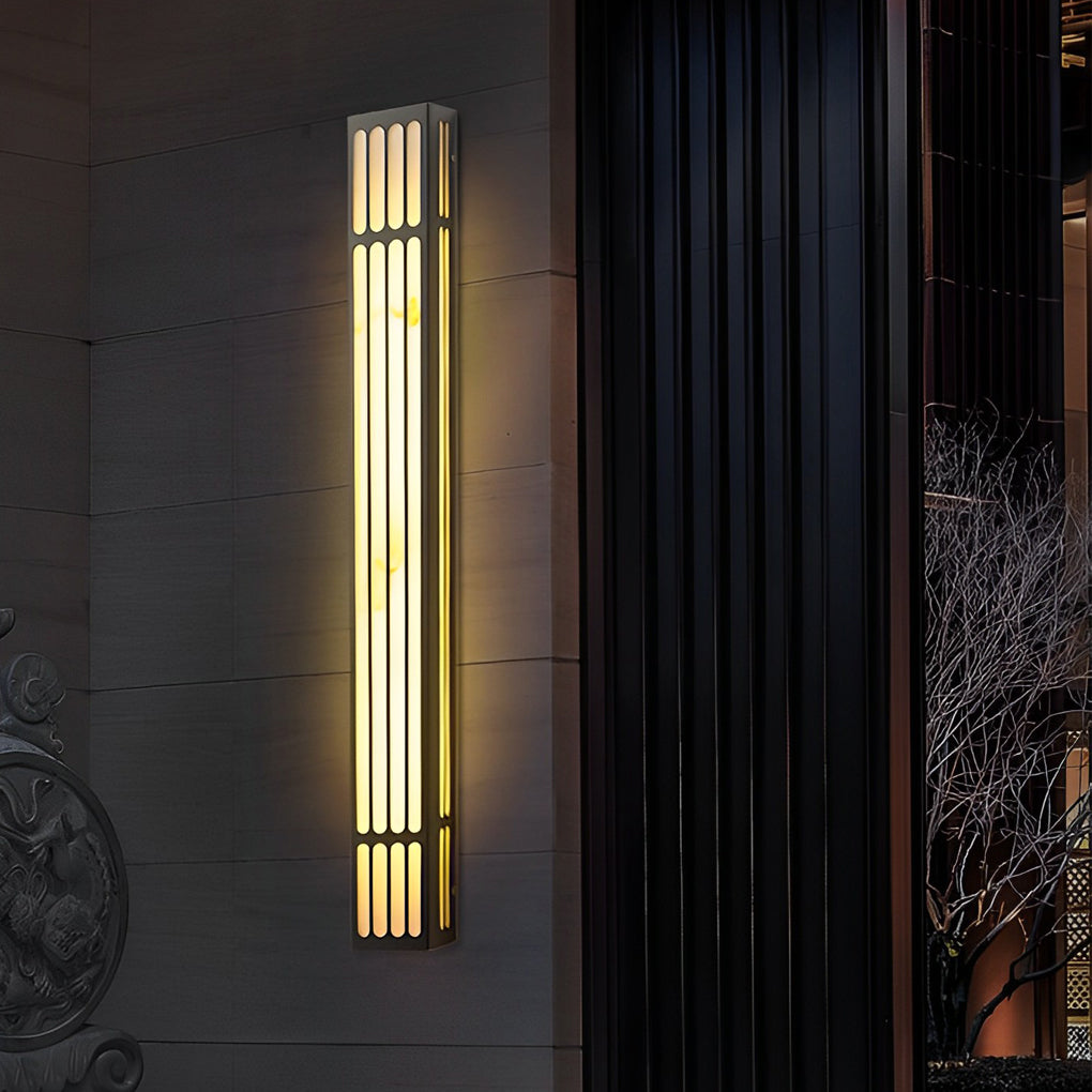 Large outdoor wall light providing directional light beside a glass railing.