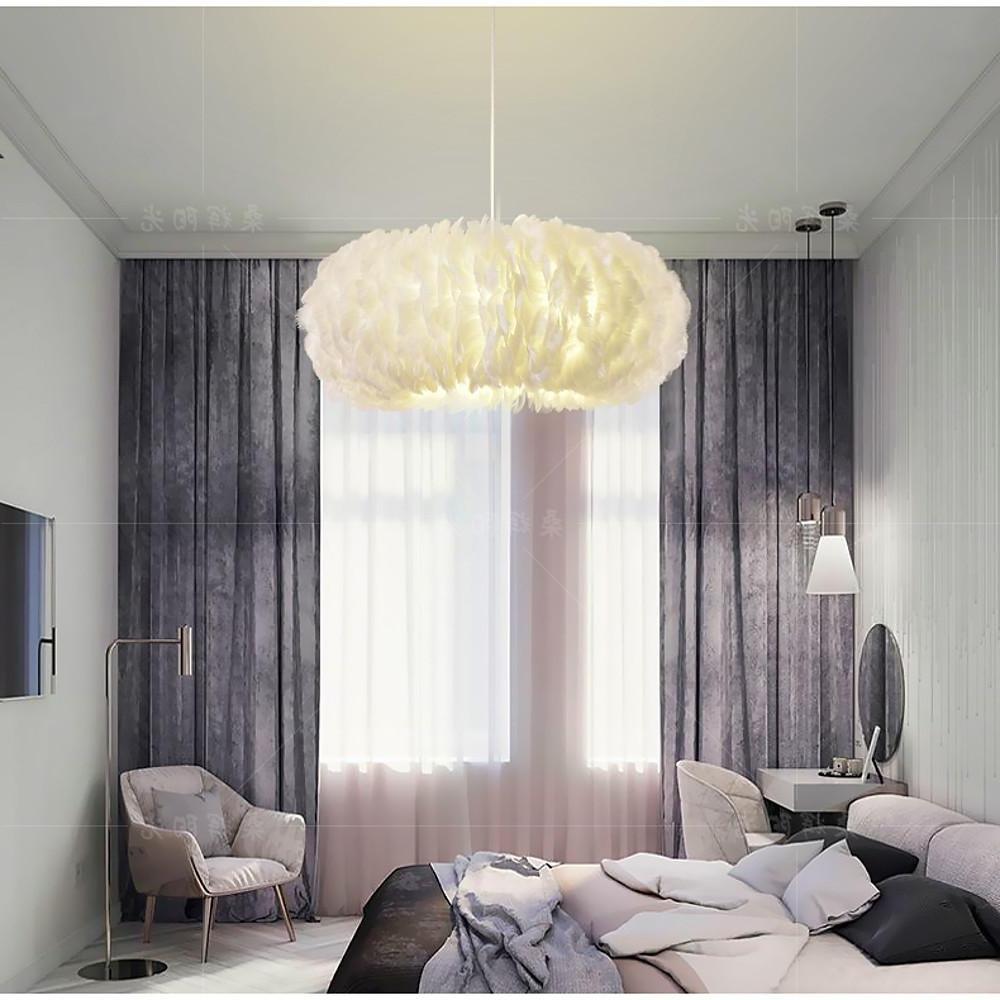 Bright modern bedroom illuminated by a large white fluffy hanging light centered above the bed.