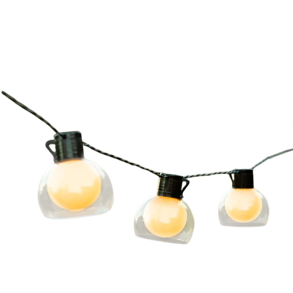 LED globe string lights shown in a close-up outdoor setting, emphasizing round bulbs and warm light output.