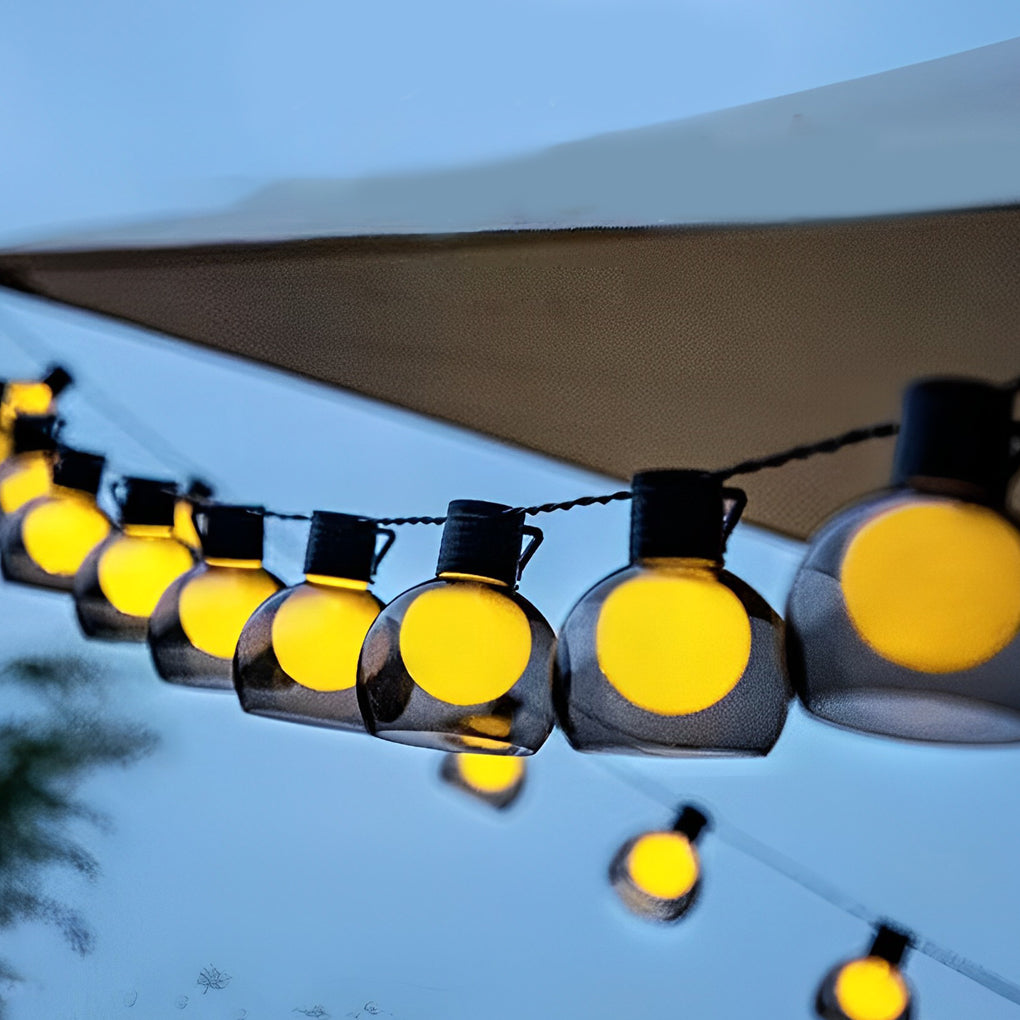 Close-up of LED globe string lights with warm bulbs, highlighting the texture and glow of outdoor decorative lighting.