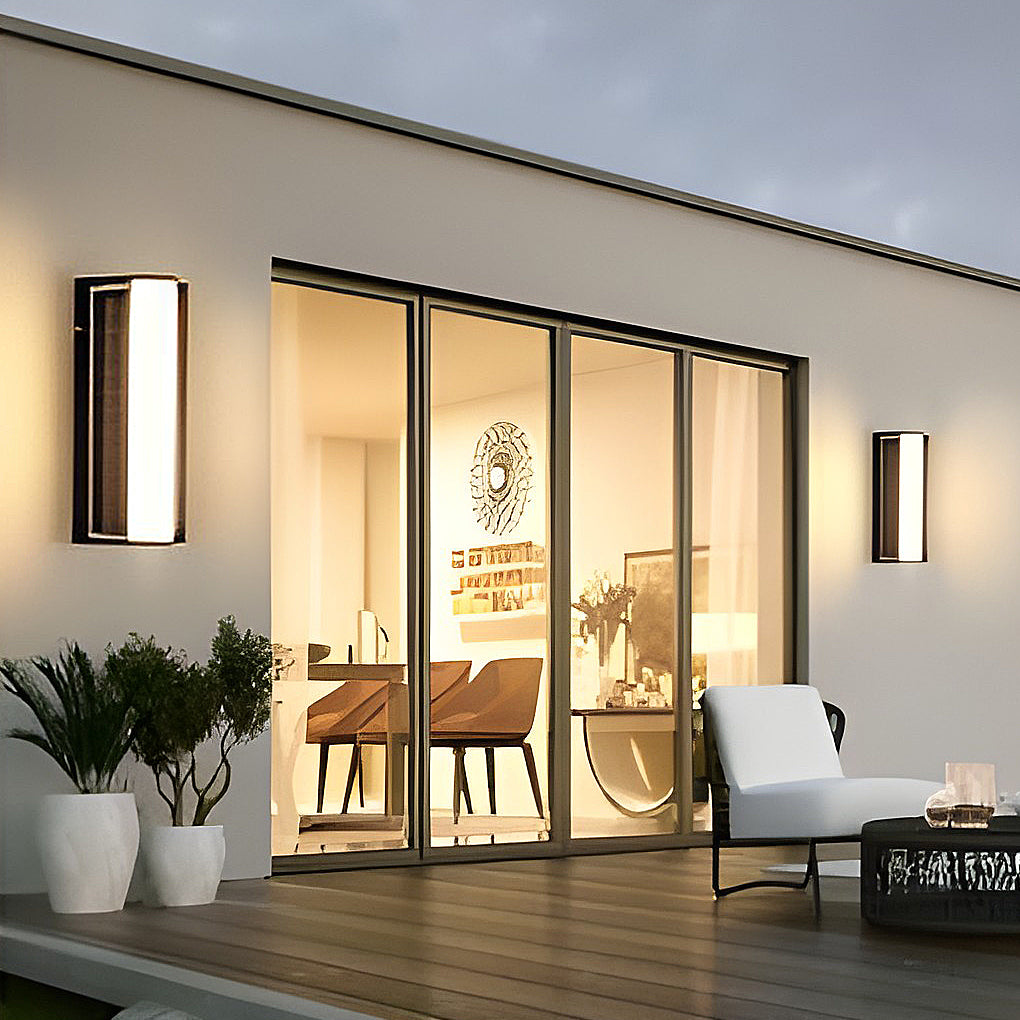 LED wall solar light installed beside a glass door, providing warm illumination for a modern patio.