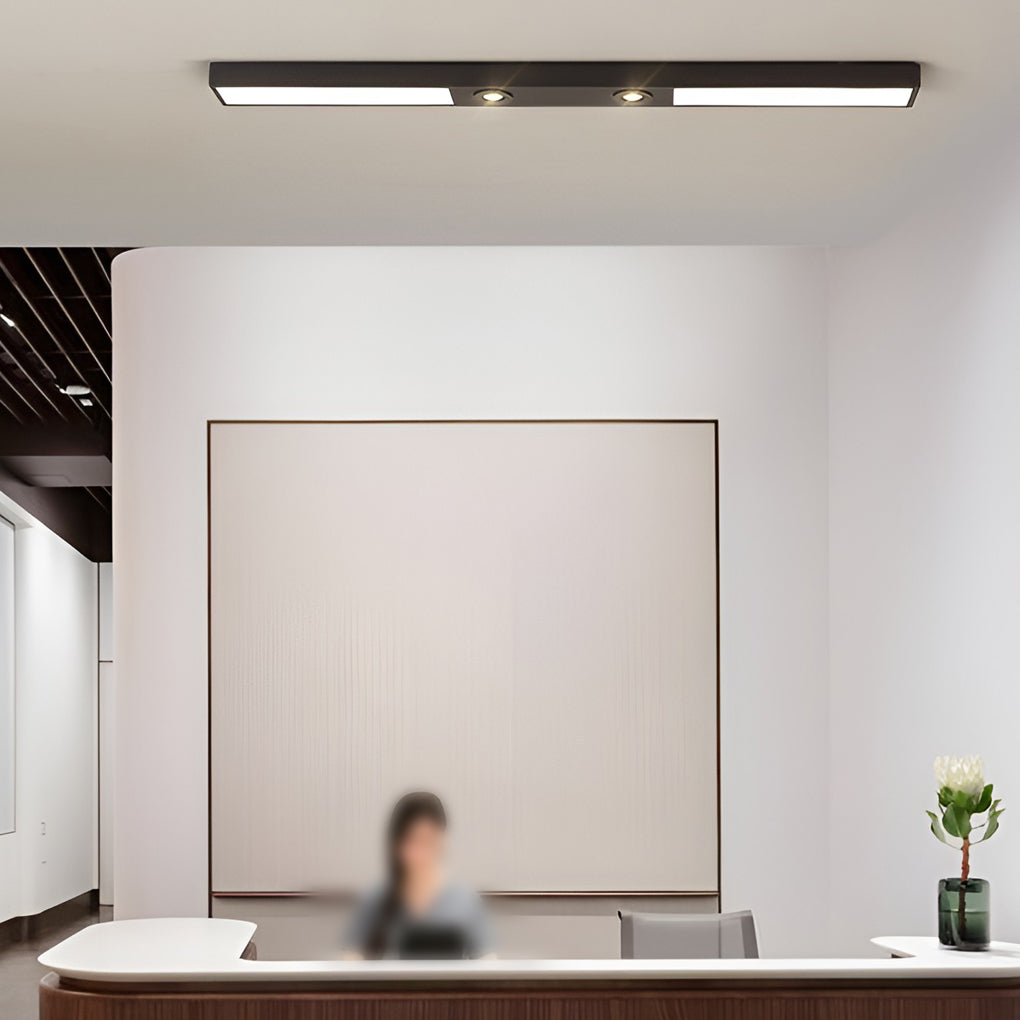 Linear ceiling pendant light above reception desk in office lobby