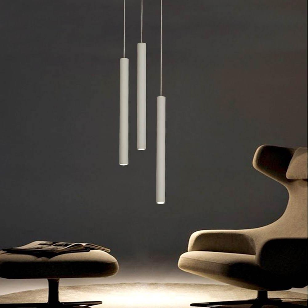 Linear cluster pendant light with white cylindrical pendants creating soft ambient lighting in a modern living space.