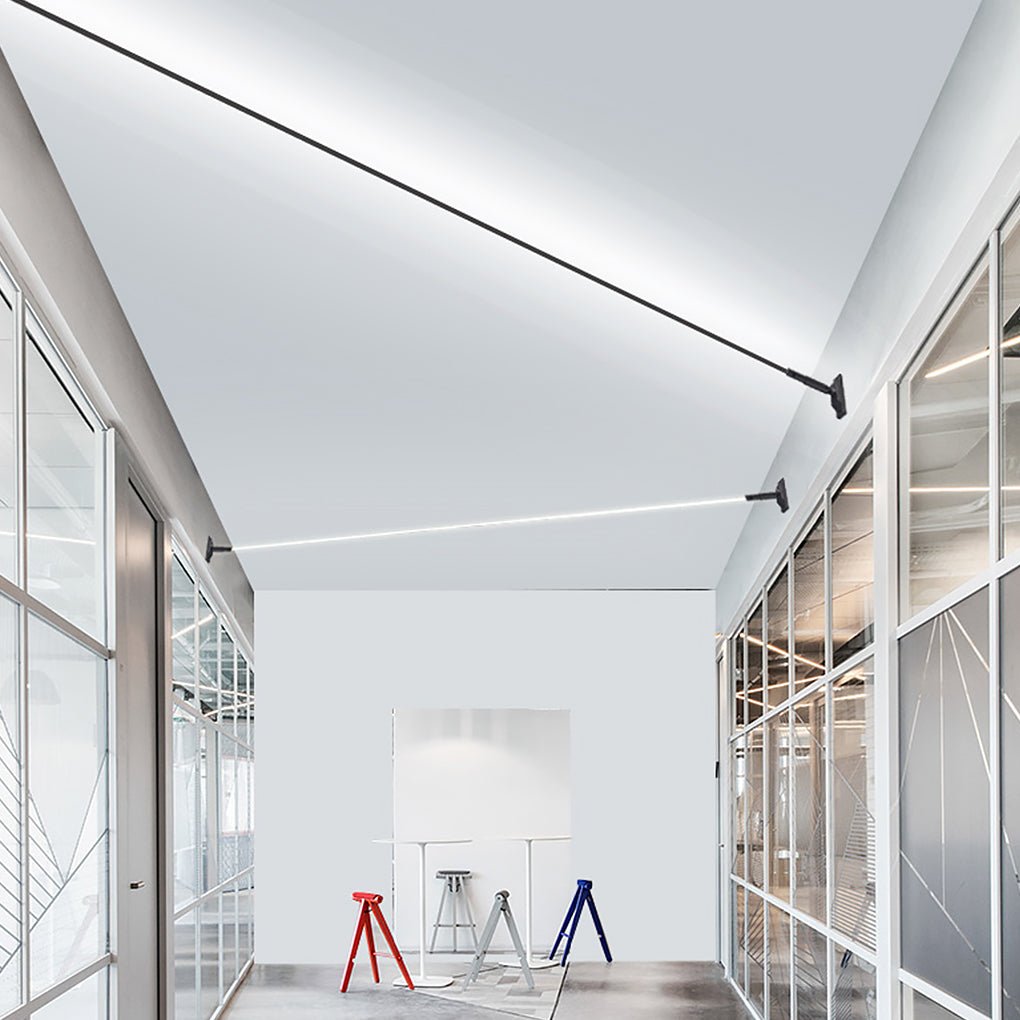 Linear led lights strips for room stretching across the ceiling of a modern white office space.