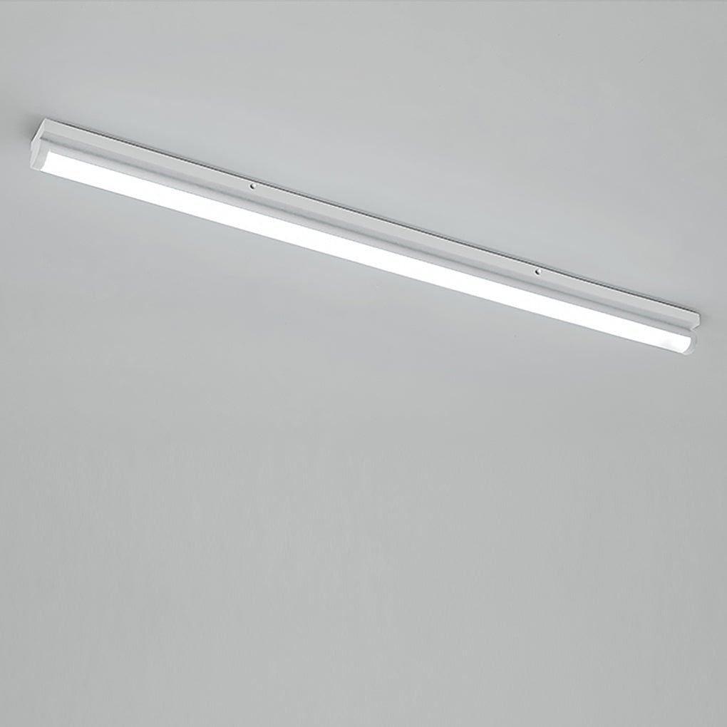 Long strip ceiling light with a black finish, mounted in a minimalist room.