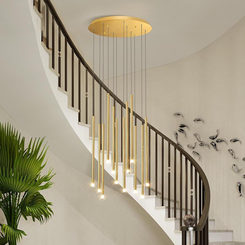 Luxury gold staircase chandelier staggered beside a curved wood staircase in large foyer areas.