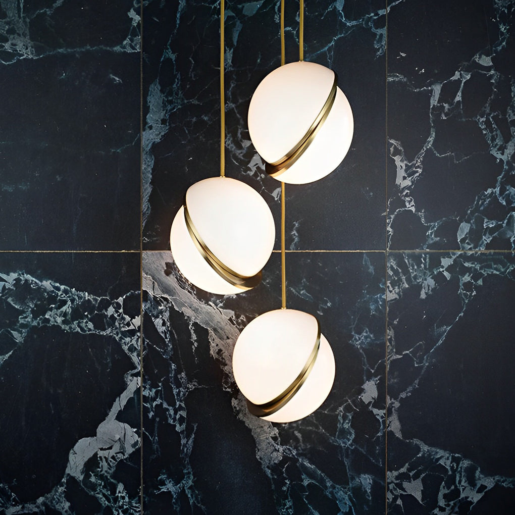 Close-up of White Spherical Pendant Light fixtures against a luxury dark green marble wall.