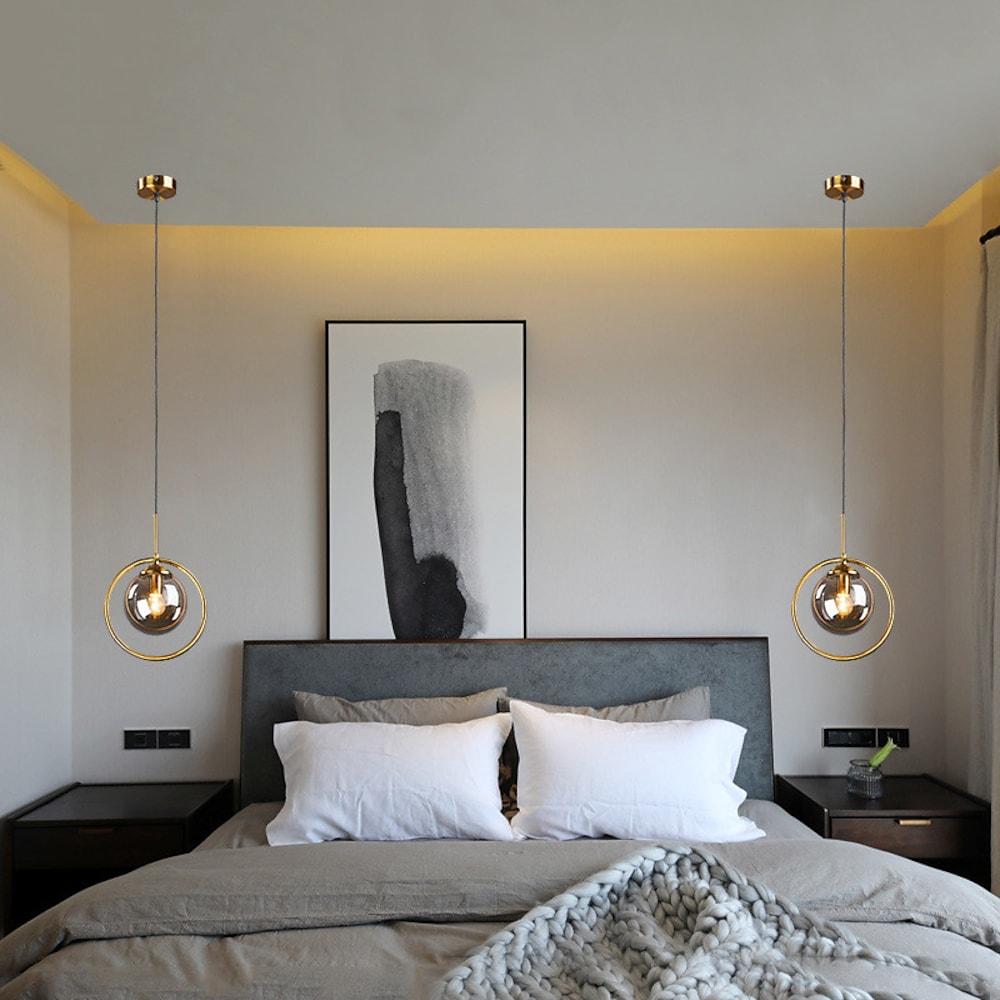 Mini gold pendant light illuminating a modern bedroom with elegant light.