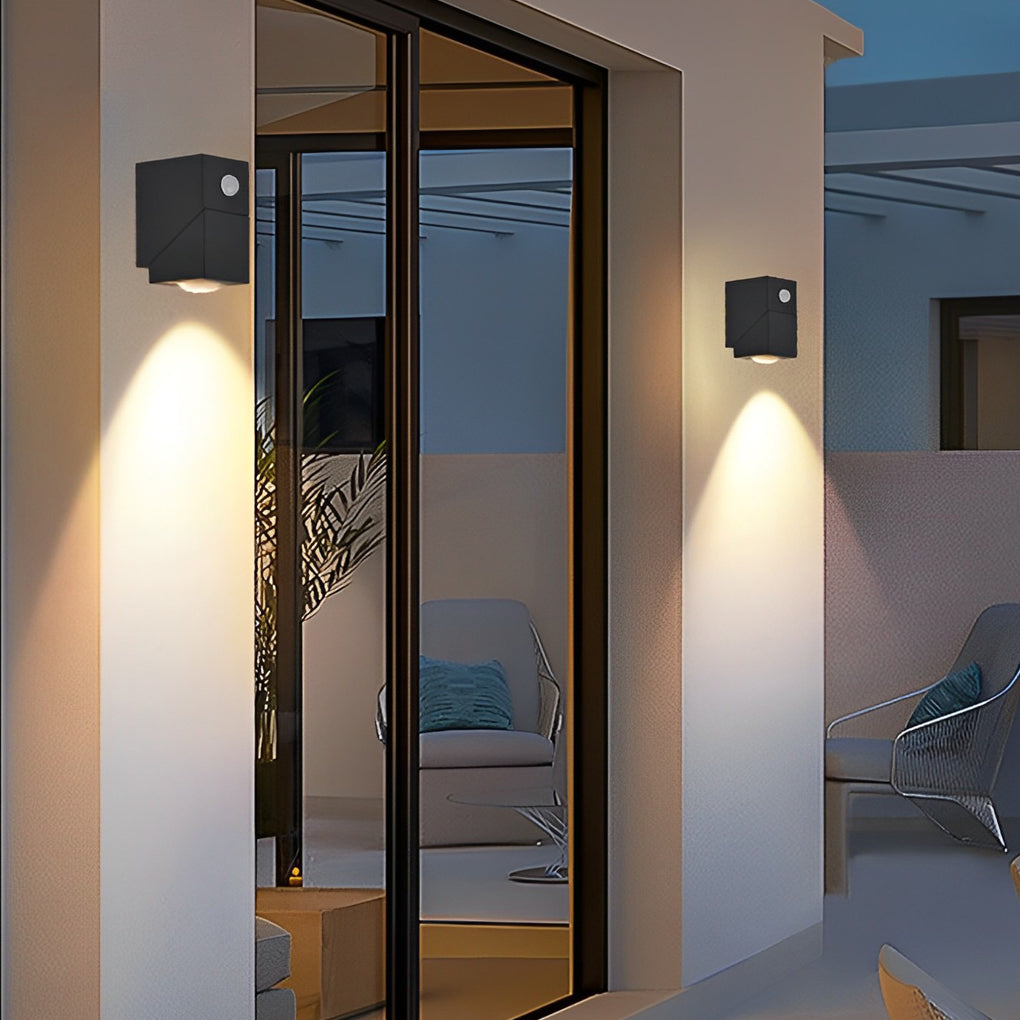 Minimalist black up down sconce outdoor beside glass door creating cozy atmosphere with soft light.