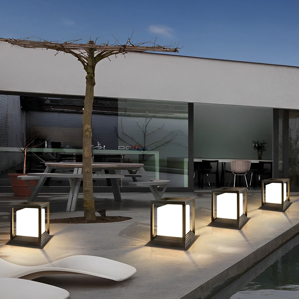Garden pedestal lights with minimalist design on outdoor terrace beside seating area.