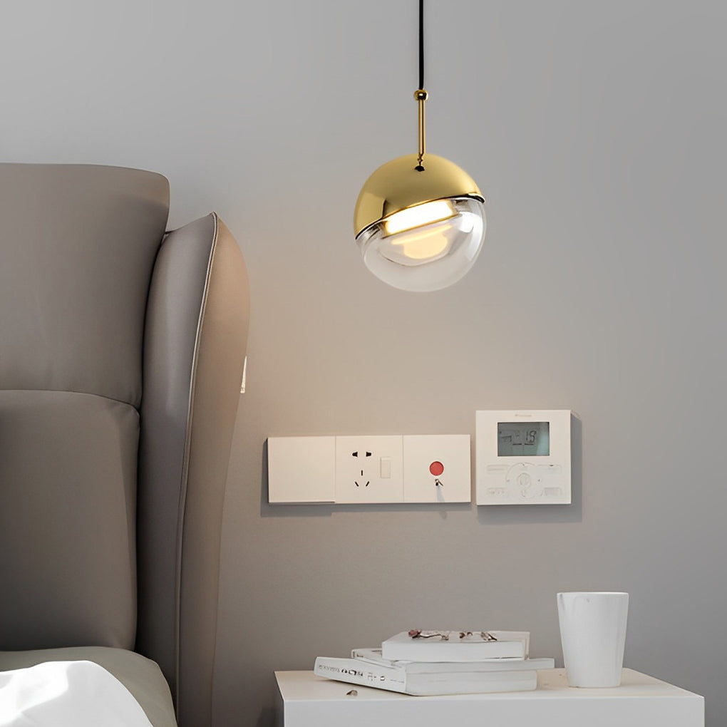 Minimalist gold globe pendant light used as a stylish bedside lamp in a modern grey bedroom.