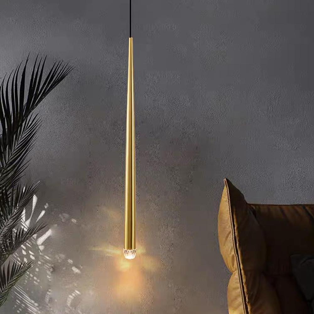 Minimalist Slim Gold Cone Pendant light hanging over a tan leather chair against textured grey wall.