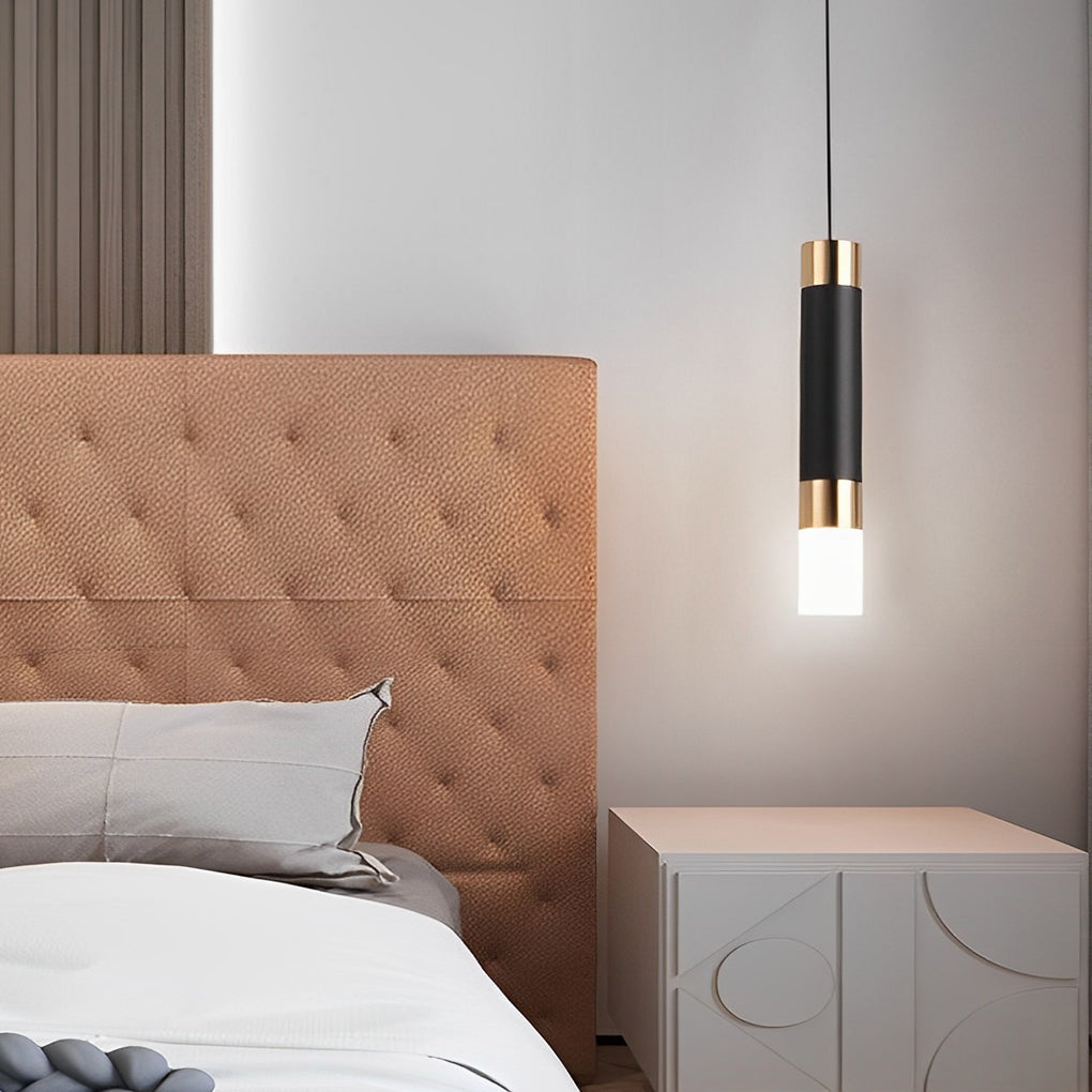 Modern black and gold LED cylinder pendant light hanging as a bedside lamp in a bright bedroom.
