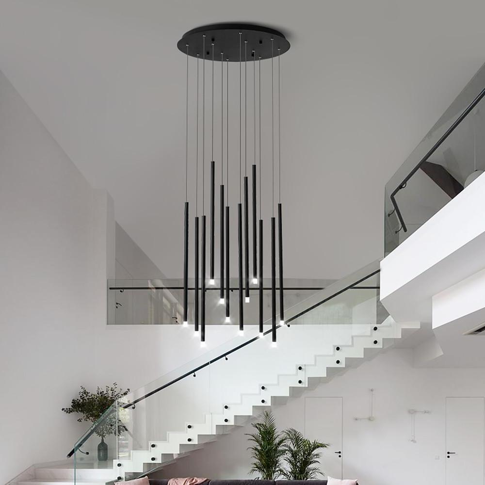 A modern black staircase chandelier cluster hanging in a high ceiling foyer with white stairs.