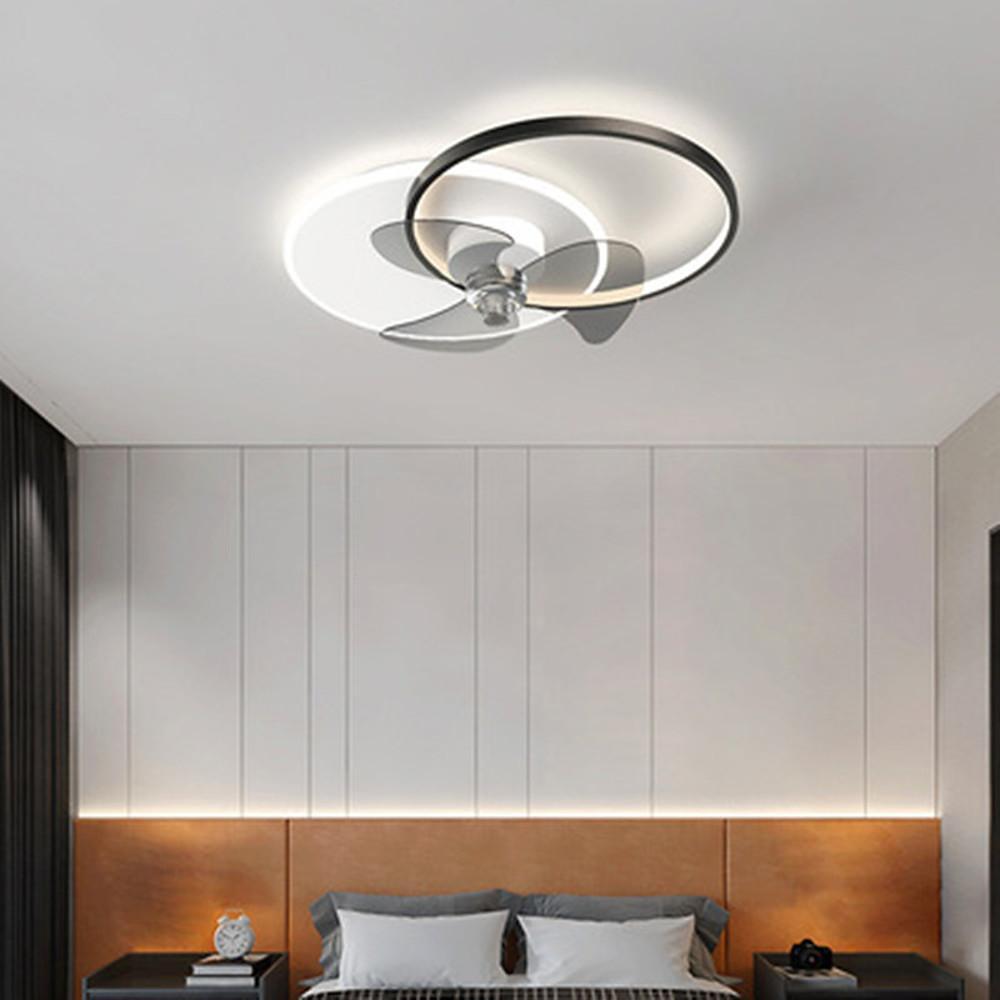 Modern black and white ceiling fan light mounted above a minimalist bed.