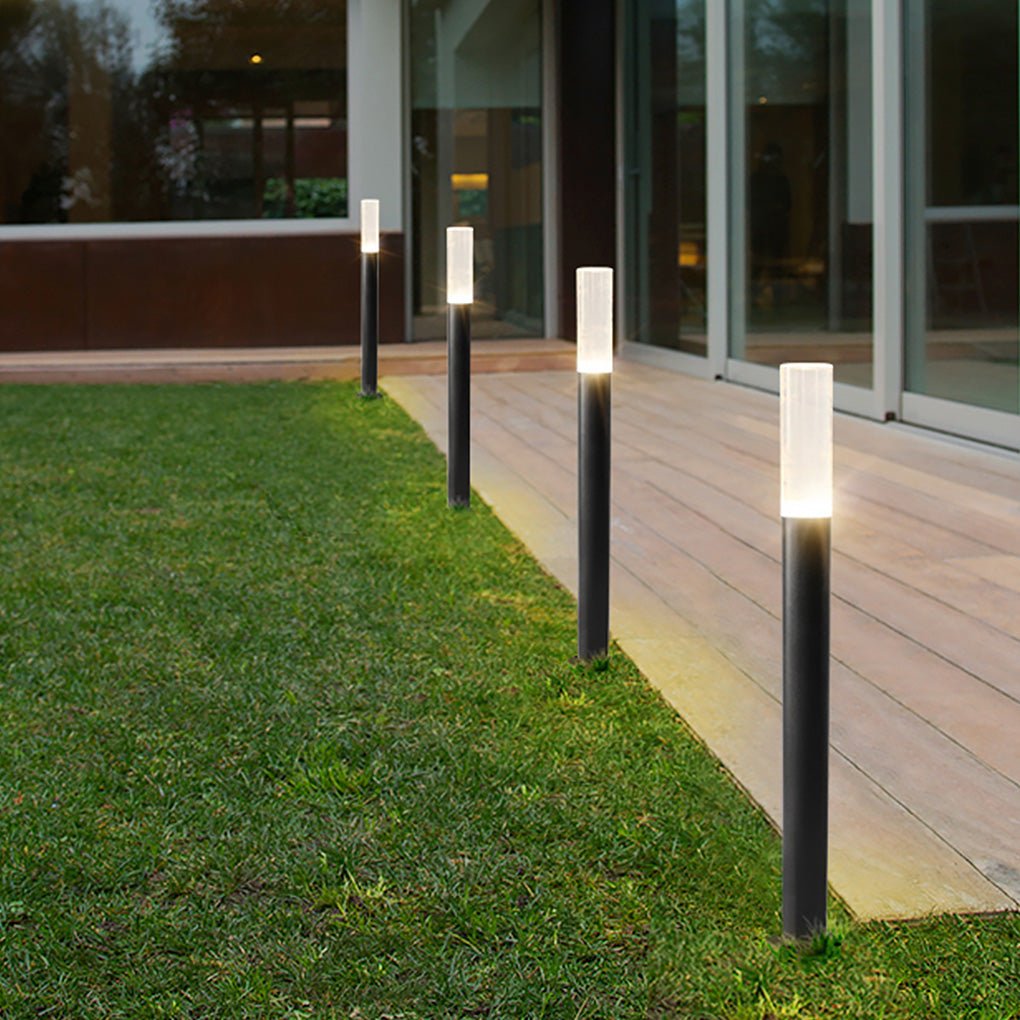 Modern bollard lighting illuminating a front yard with a minimalist design.