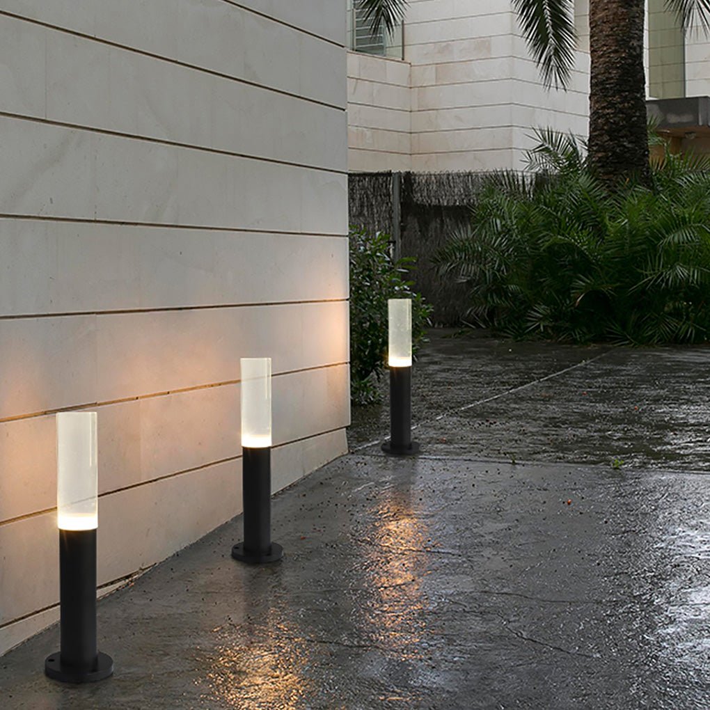 Modern bollard lighting casting light on a stone pathway beside a modern house.