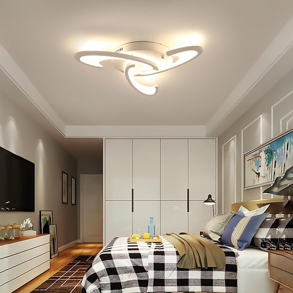 Modern curved LED ceiling light mounted in a minimalist bedroom interior.
