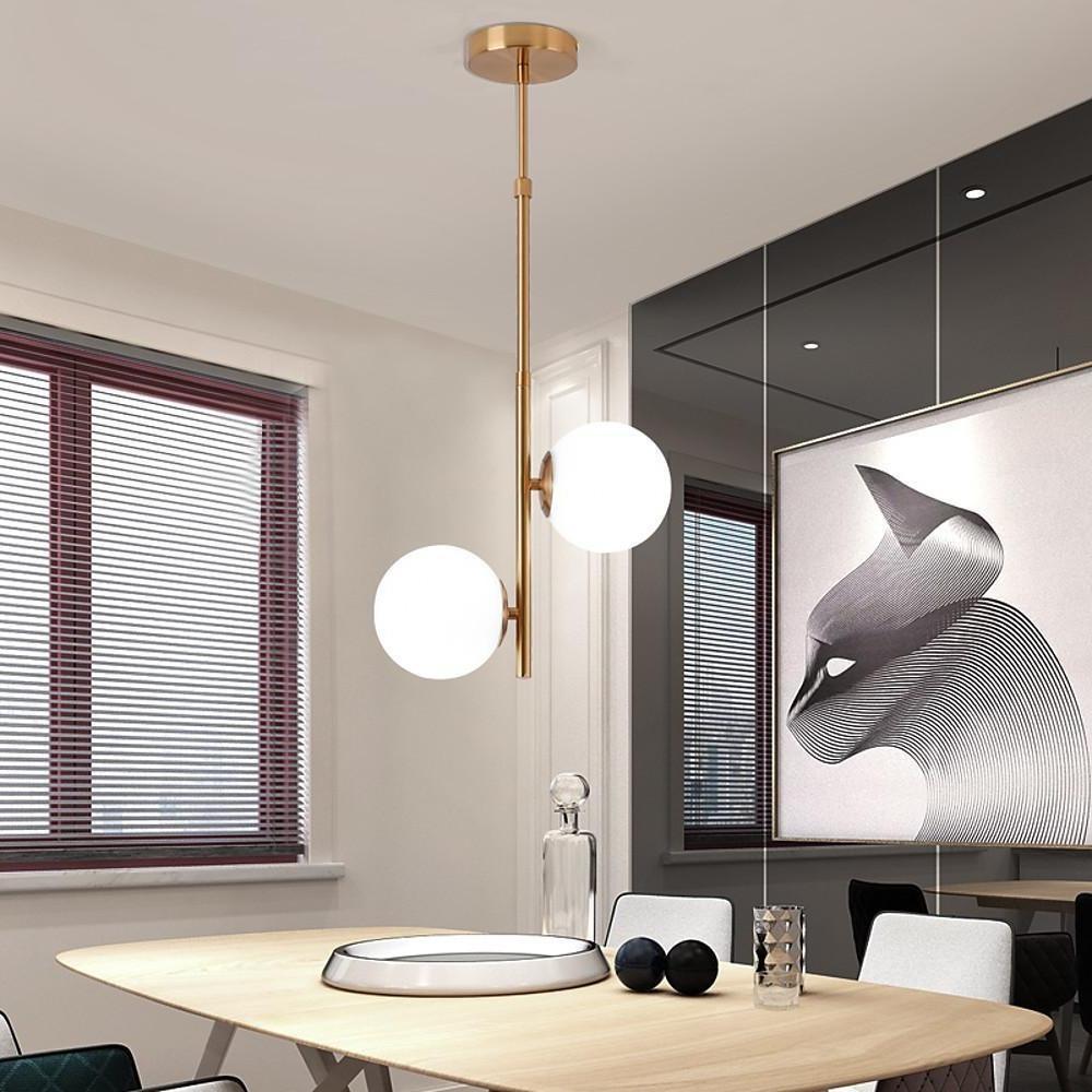 Chic Vertical Gold Pendant light over a console table and mirror in a modern home entry.