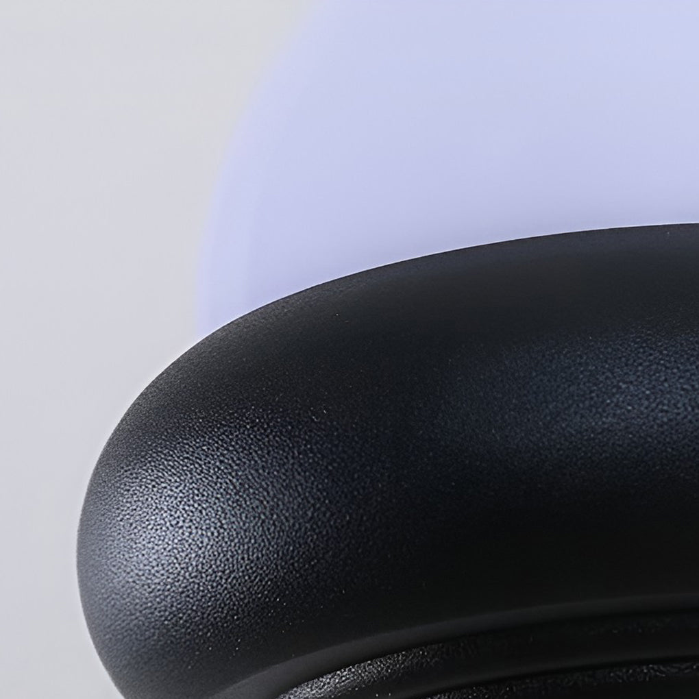 Close-up of a modern globe wall sconce in black, showcasing its sleek design and warm light.