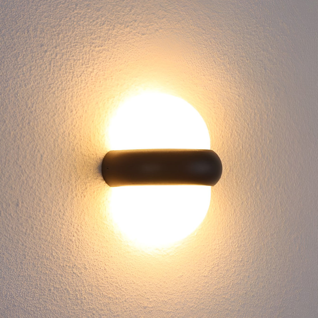 Modern globe wall sconce in black, mounted near a doorway for stylish and functional outdoor lighting.