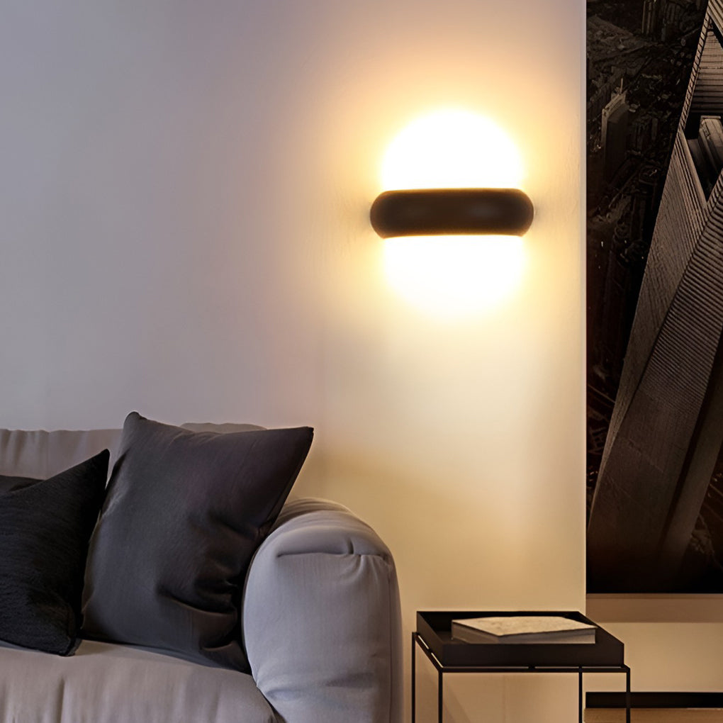 Modern globe wall sconce with black frame, providing elegant lighting near an outdoor entrance.