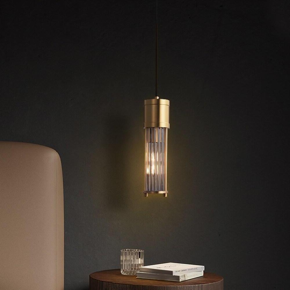 Modern gold cylinder pendant light used as accent lighting.