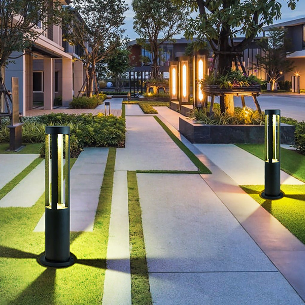 Modern outdoor bollard lights illuminating a front yard with stepping stones.