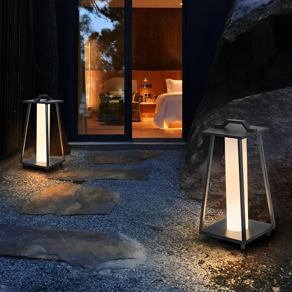 Modern portable outdoor lantern lighting a stone pathway near a modern house exterior.