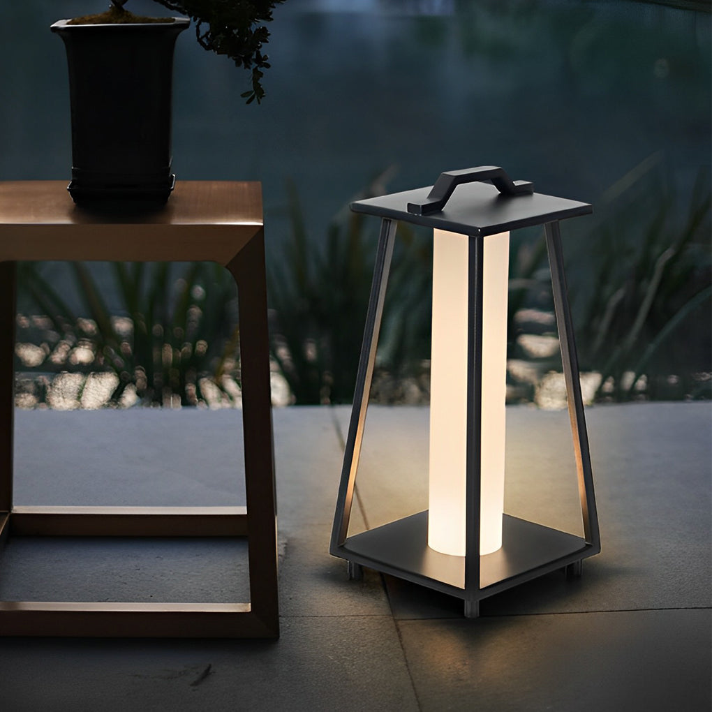 Modern portable outdoor lantern displayed on a wooden table in a refined outdoor living space.