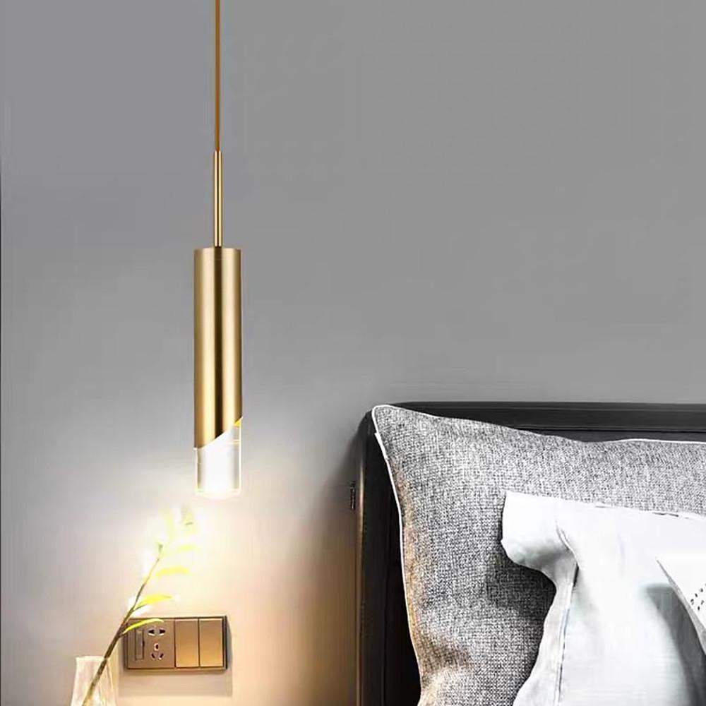 Modern Slanted Gold Cylinder Pendant light used as a minimalist bedside lamp in a grey bedroom.