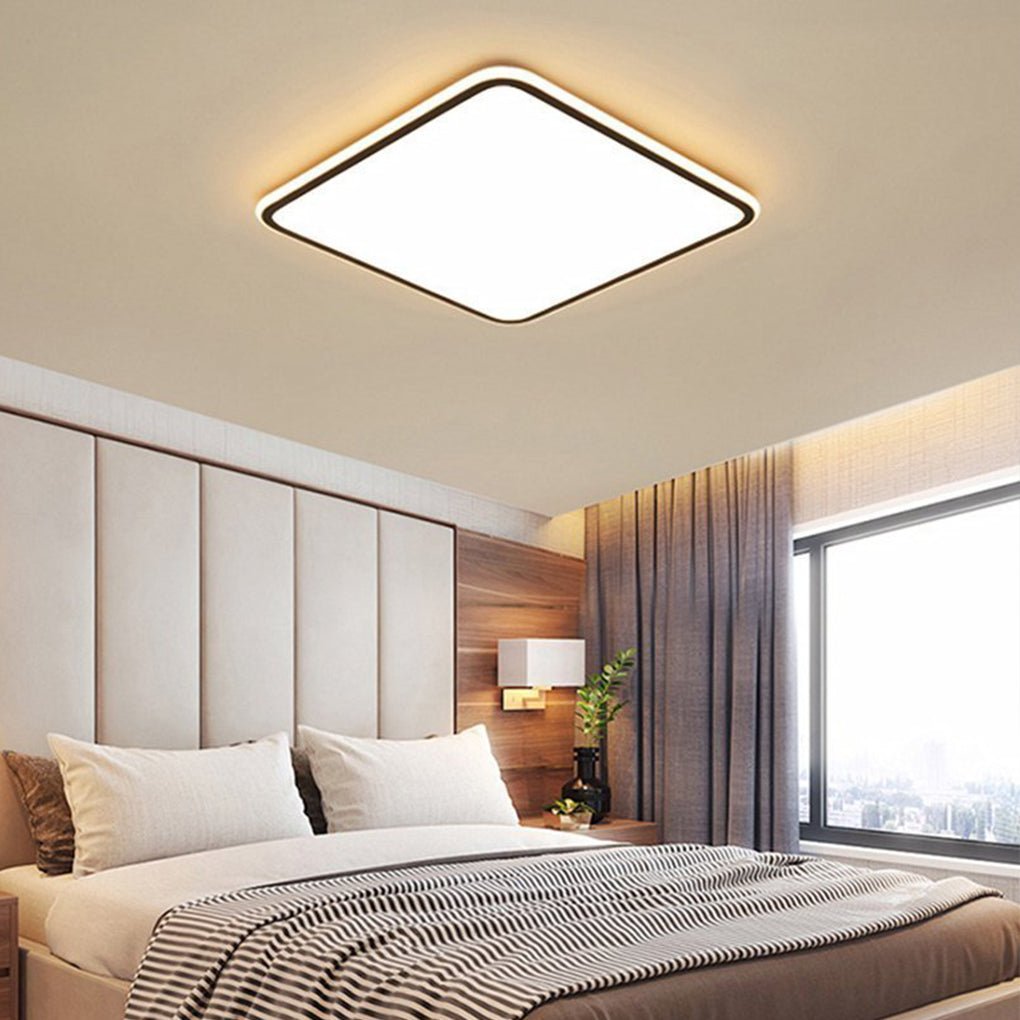 Modern square LED ceiling light providing ambient lighting in a modern bedroom.