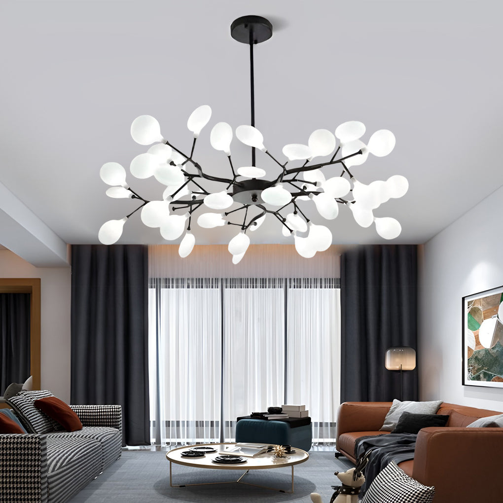 Modern tree branch chandelier providing ambient light above a cozy sofa area.