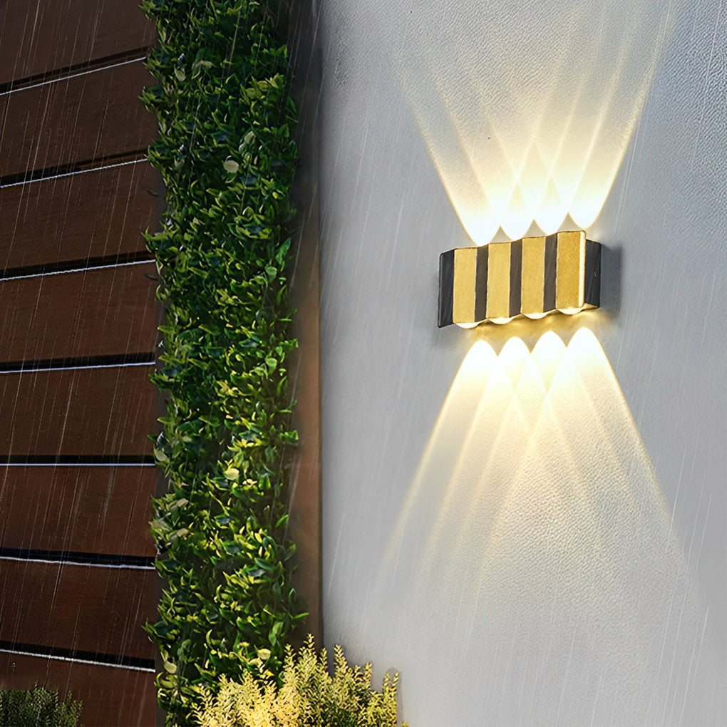 Modern up and down wall lights mounted near an entryway, creating a welcoming glow and accentuating the modern facade.