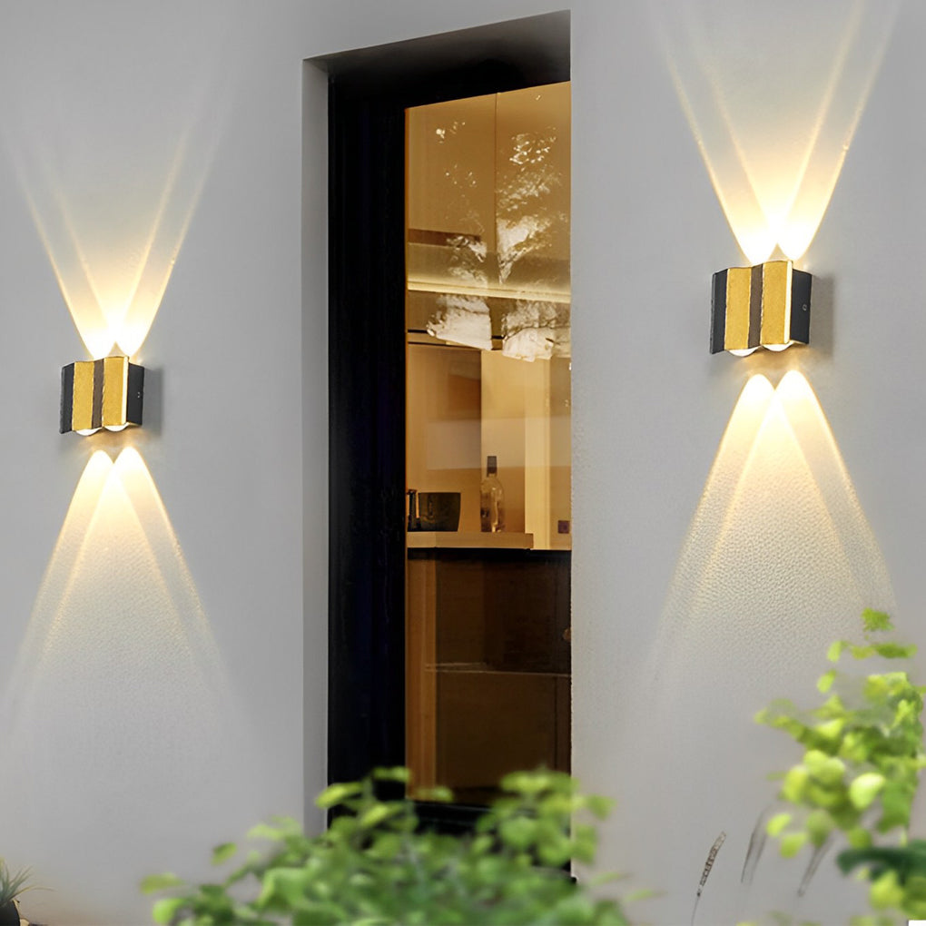 Modern up and down wall lights placed next to a glass door, providing elegant exterior illumination and visual balance.