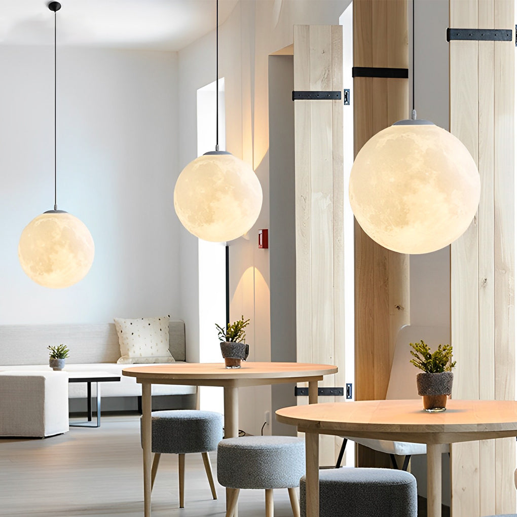 Moon globe pendant light set installed in modern dining space with wood accents.
