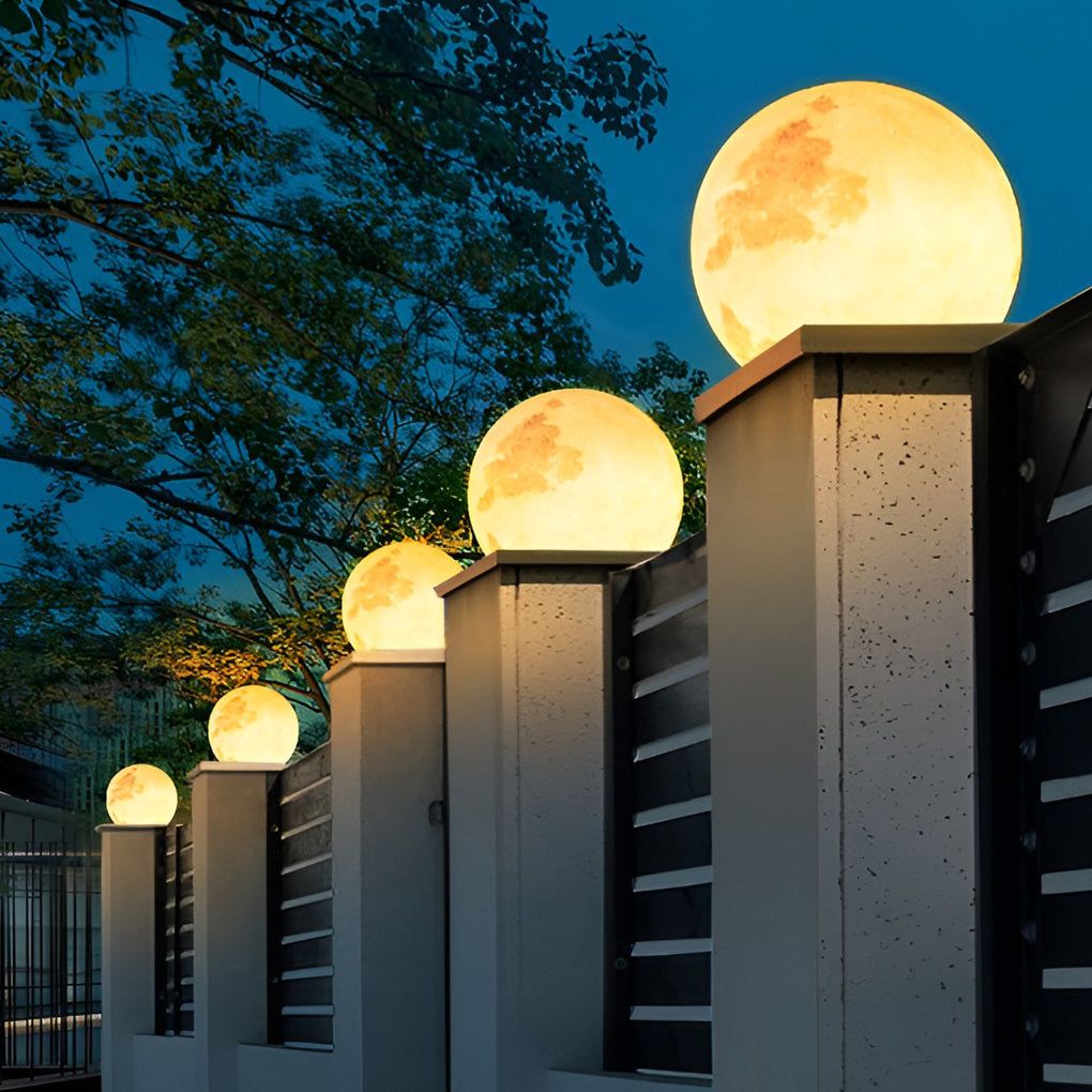 Moon pillar lights with detailed moon texture, installed on stone pillars along garden pathway.