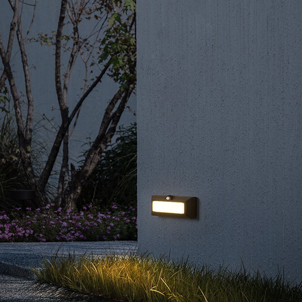 Motion sensor LED step lights installed on a concrete wall with greenery.