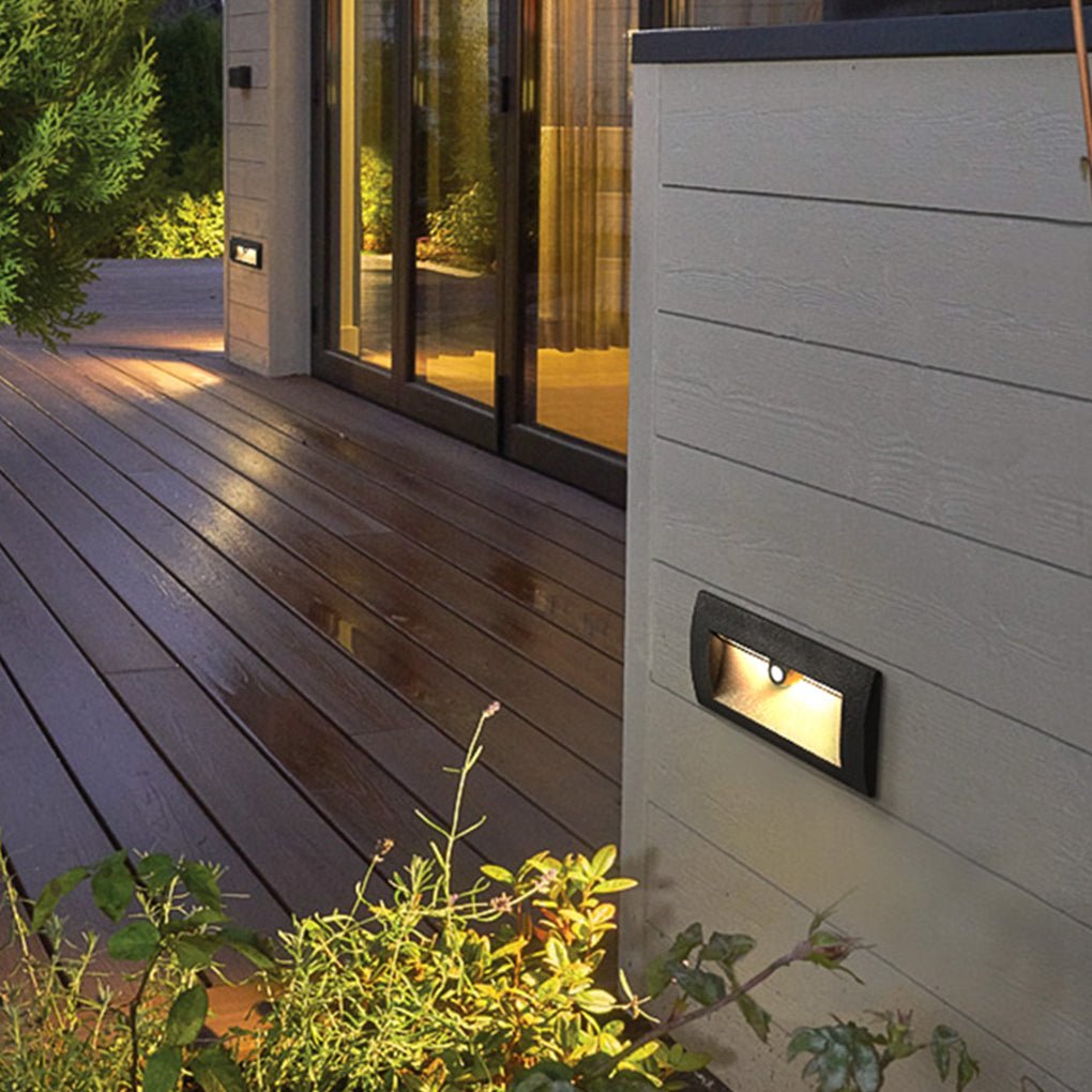 Motion sensor LED step lights casting light on a garden pathway at dusk.