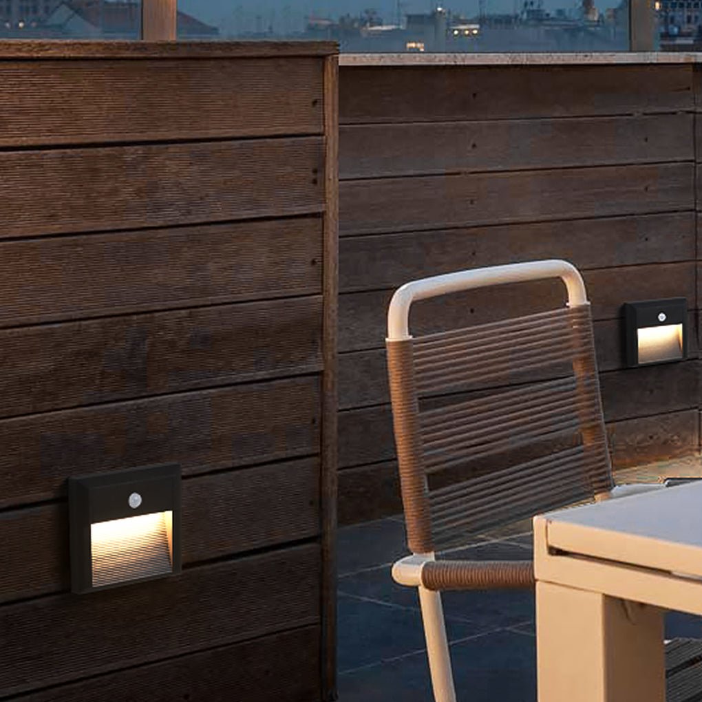 Motion sensor LED step lights illuminating a wooden deck near outdoor furniture.