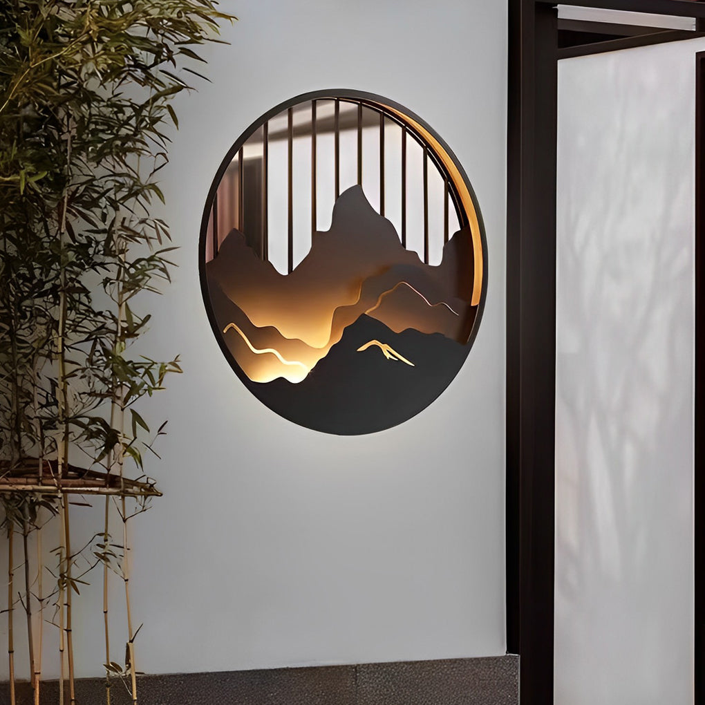 Mountain LED wall light mounted on exterior wall beside bamboo landscaping.