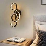 Musical note wall light illuminating a modern bedroom with warm, artistic glow.