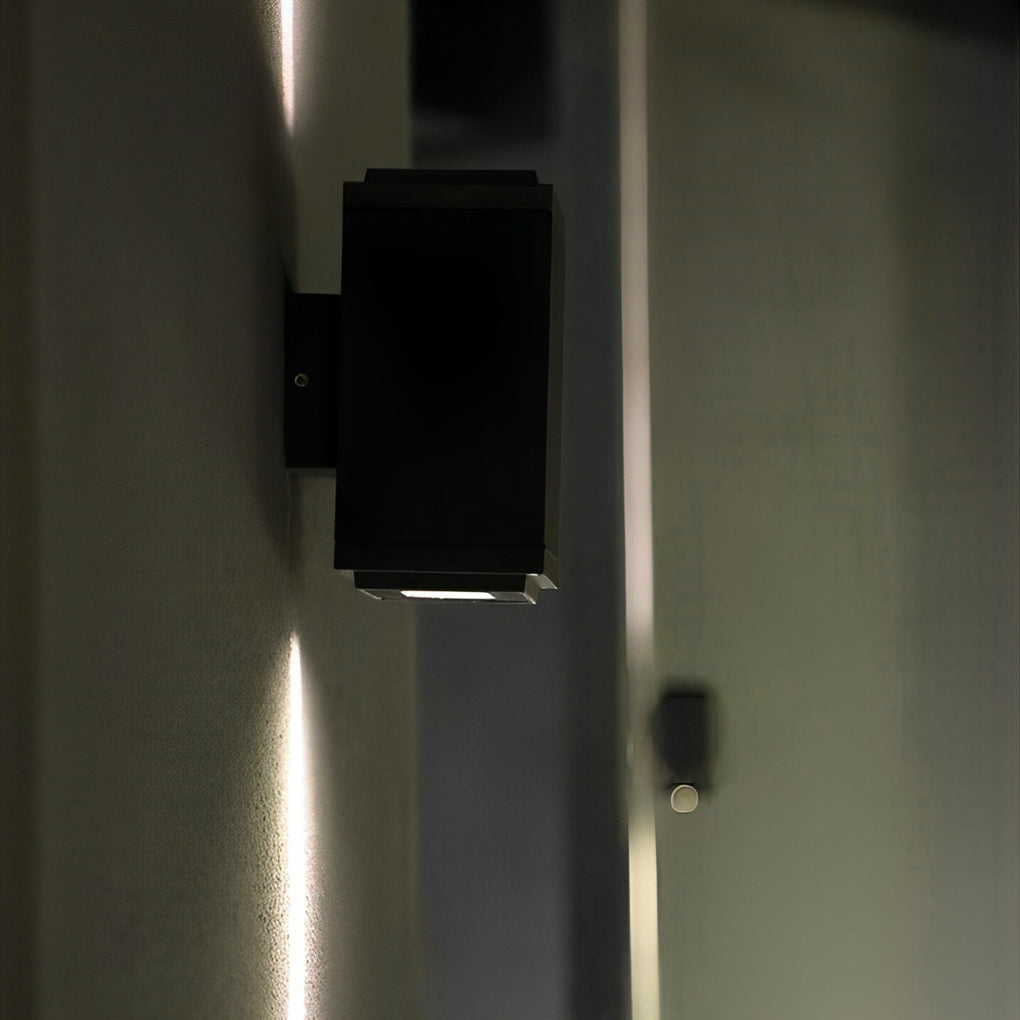 Modern narrow beam outdoor wall sconce creating vertical light lines on exterior building facade.