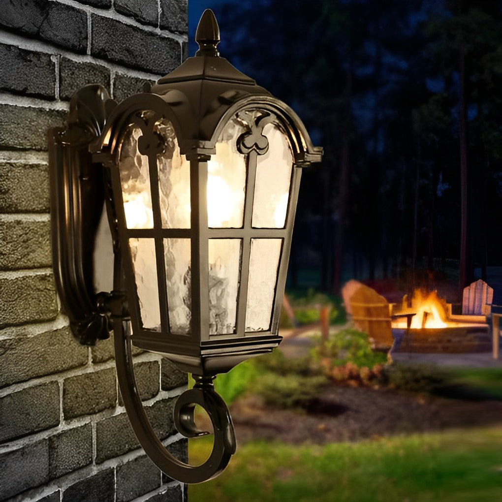 Outdoor black sconce providing warm light on a brick wall near a cozy outdoor seating area.
