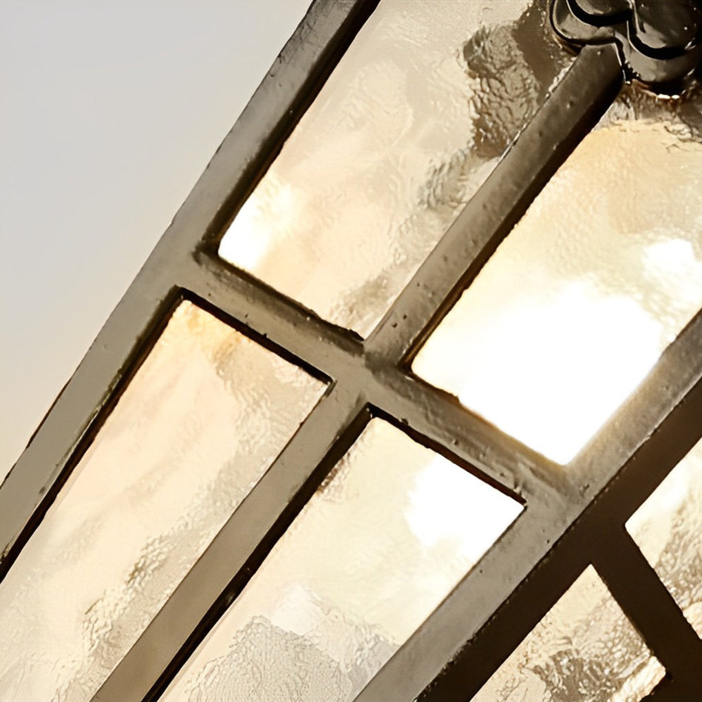 Outdoor black sconce with a classic lantern style, mounted on a brick wall.