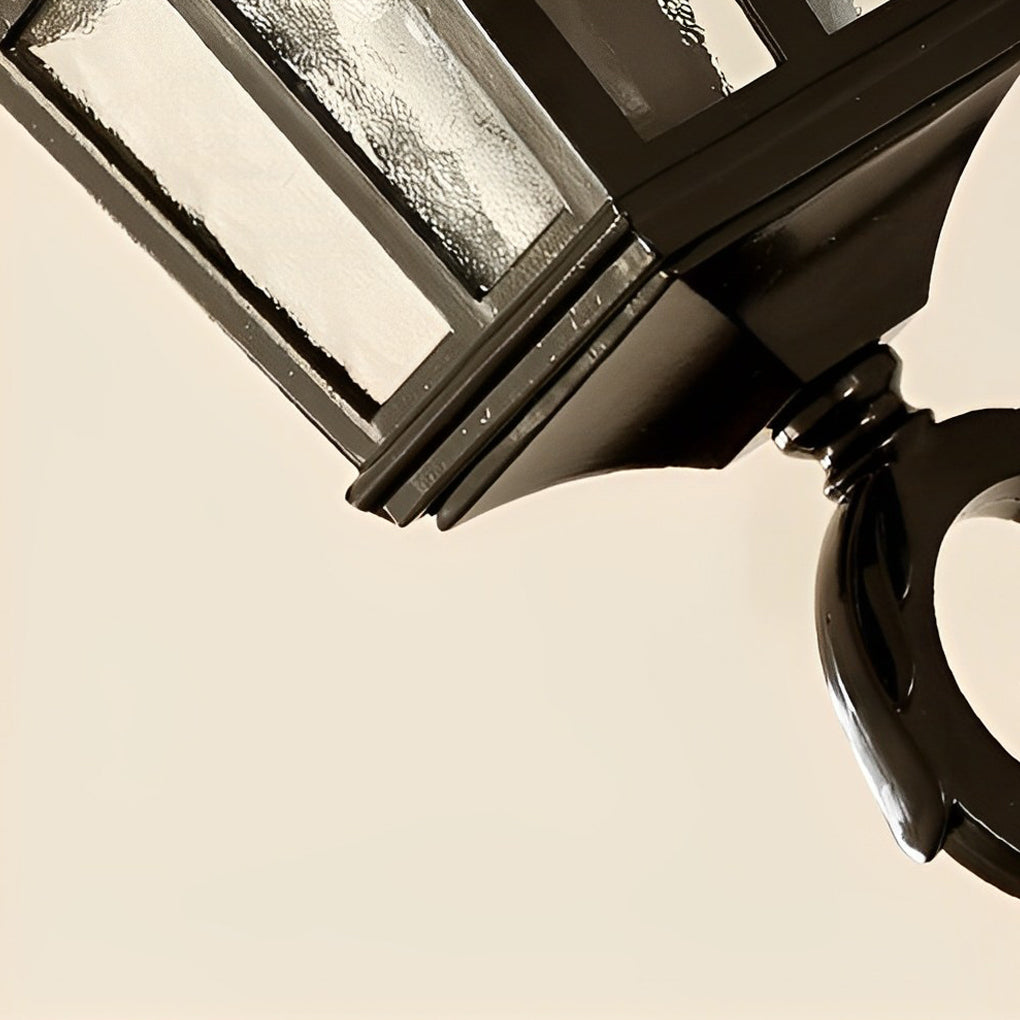 Close-up of an outdoor black sconce, showcasing its intricate design and warm light.