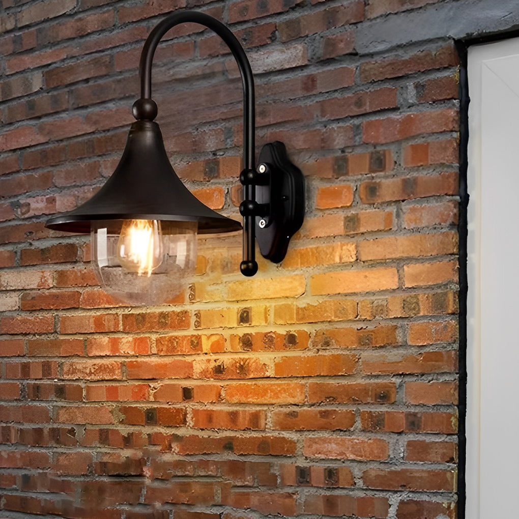Outdoor black wall light mounted on a brick wall, providing elegant illumination near a garden.