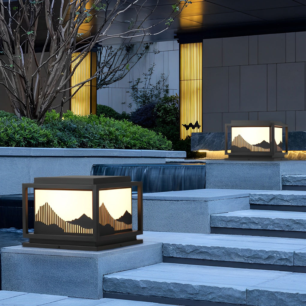Outdoor brick pillar lights with close-up of its mountain silhouette design and light output.